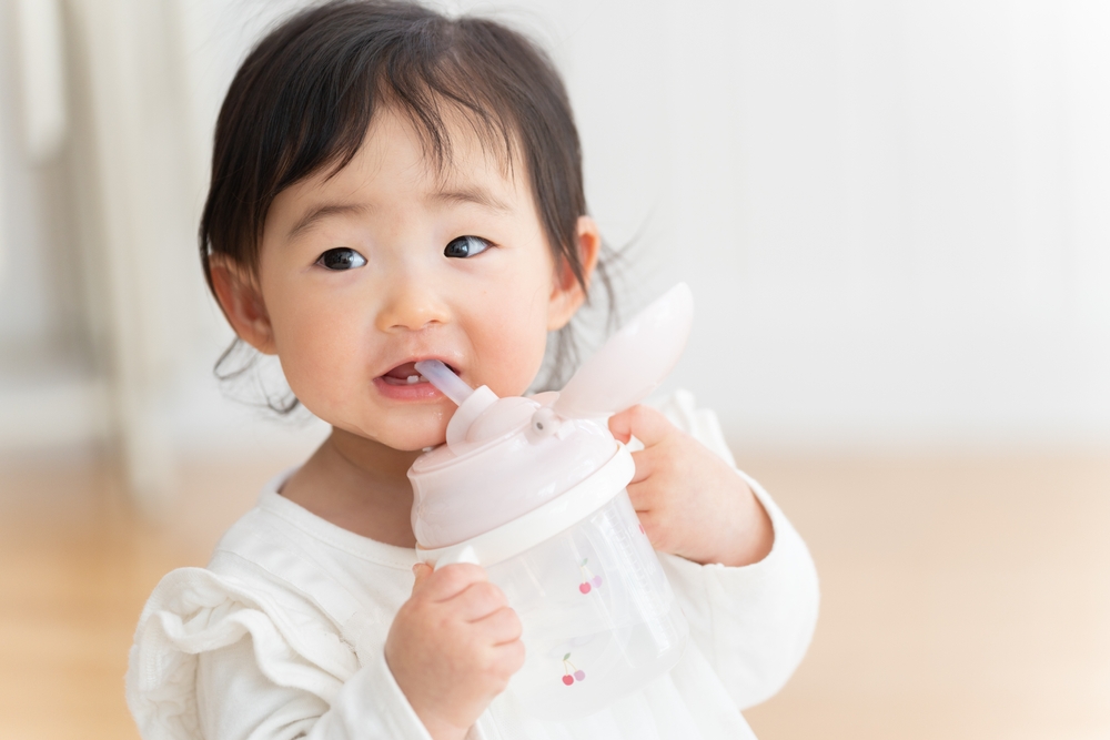 เด็กกำลังดื่มน้ำจากกระติกน้ำเก็บความเย็นสำหรับเด็ก